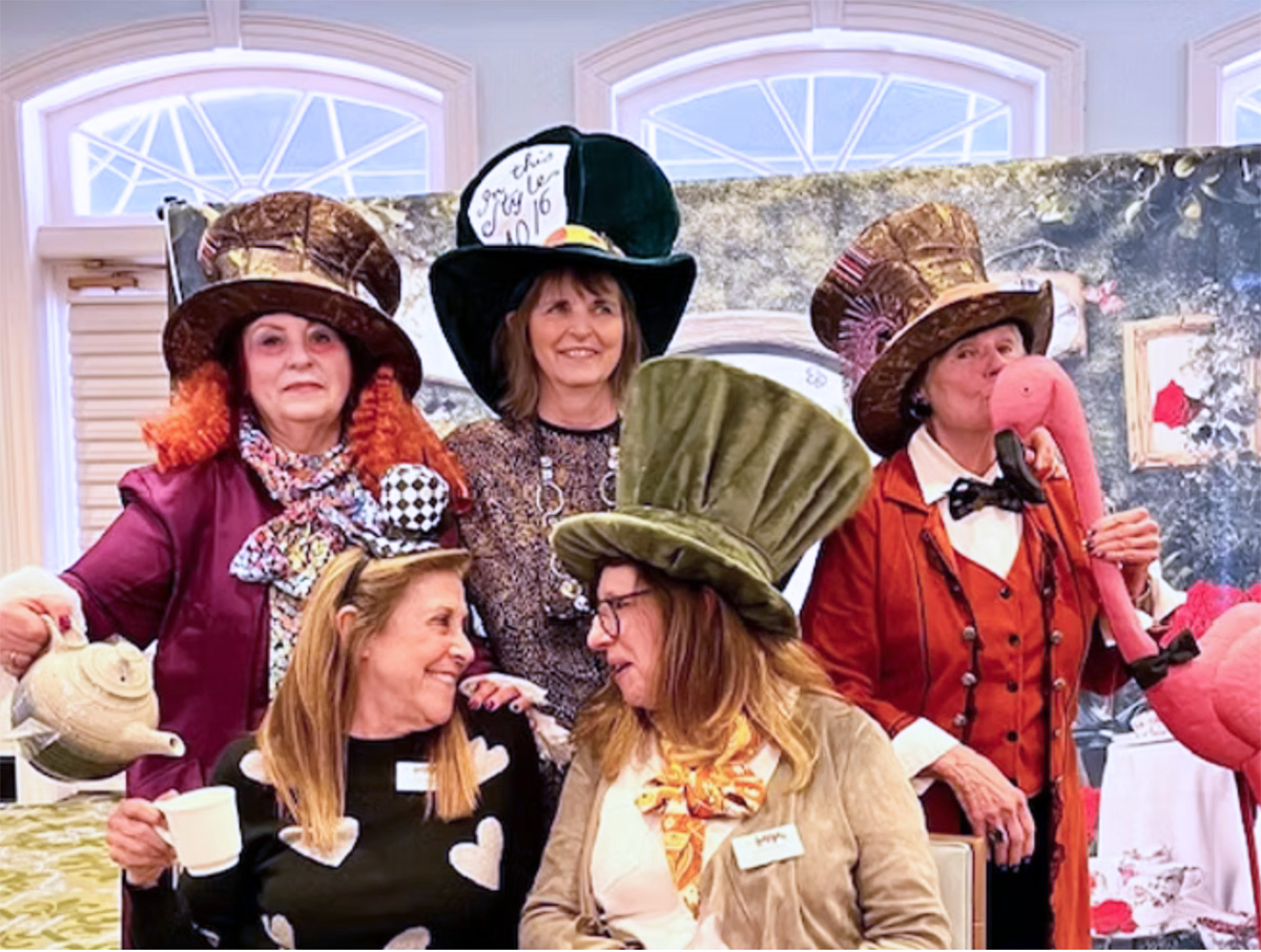 Leslie Scher (seated left) at the spring Alice in Wonderland Party