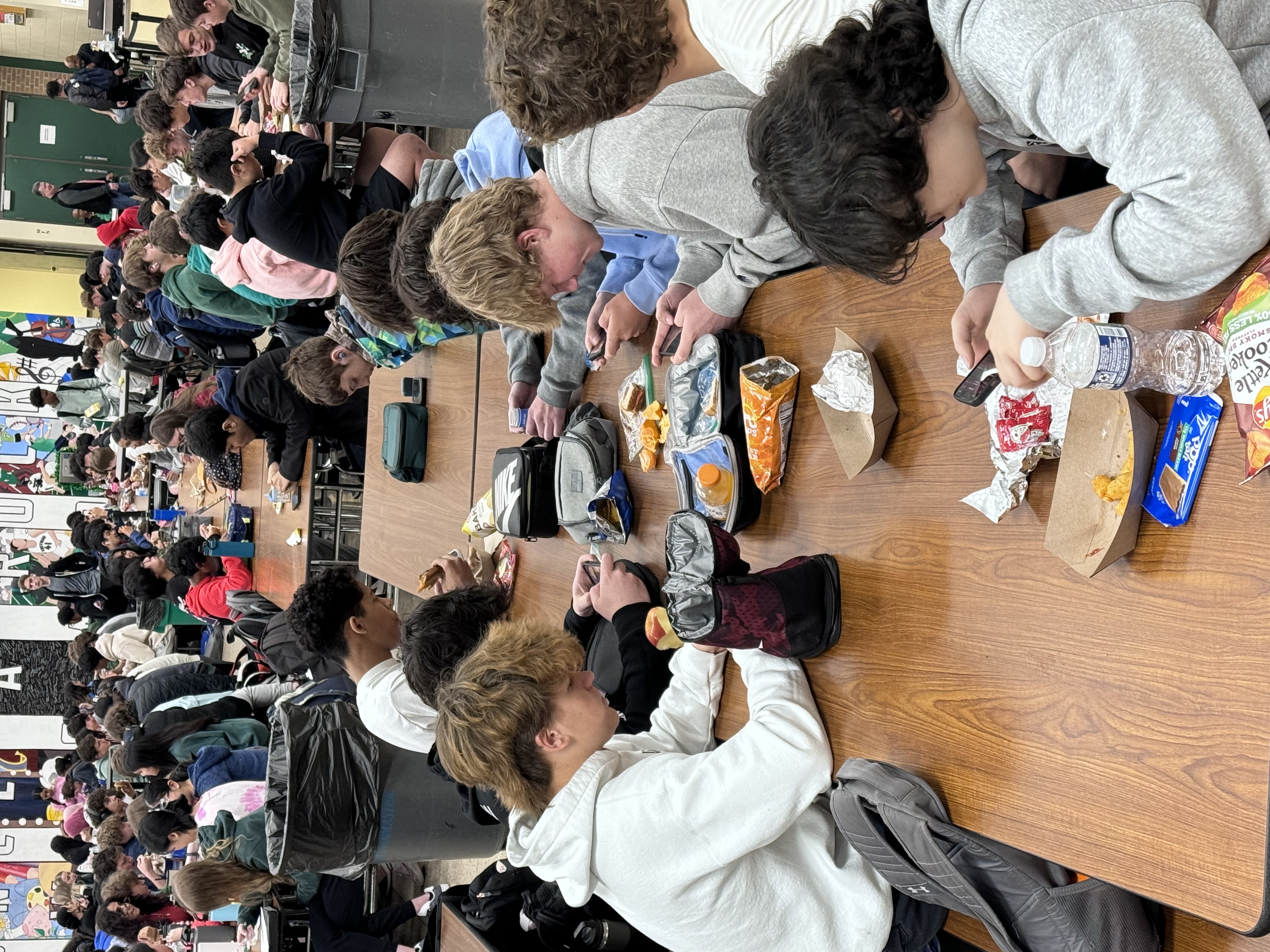 Lunchtime in the digital world: Students at Coffman High School scroll, swipe, and snack in the cafeteria.