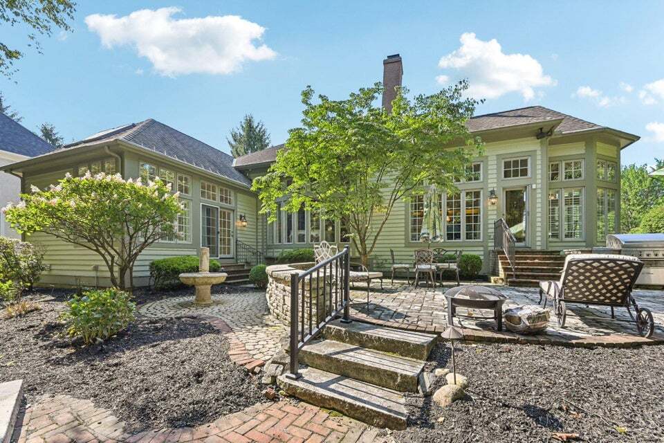 The paver patio connects multiple entertaining spaces, from firepit to grill, making gatherings effortless.