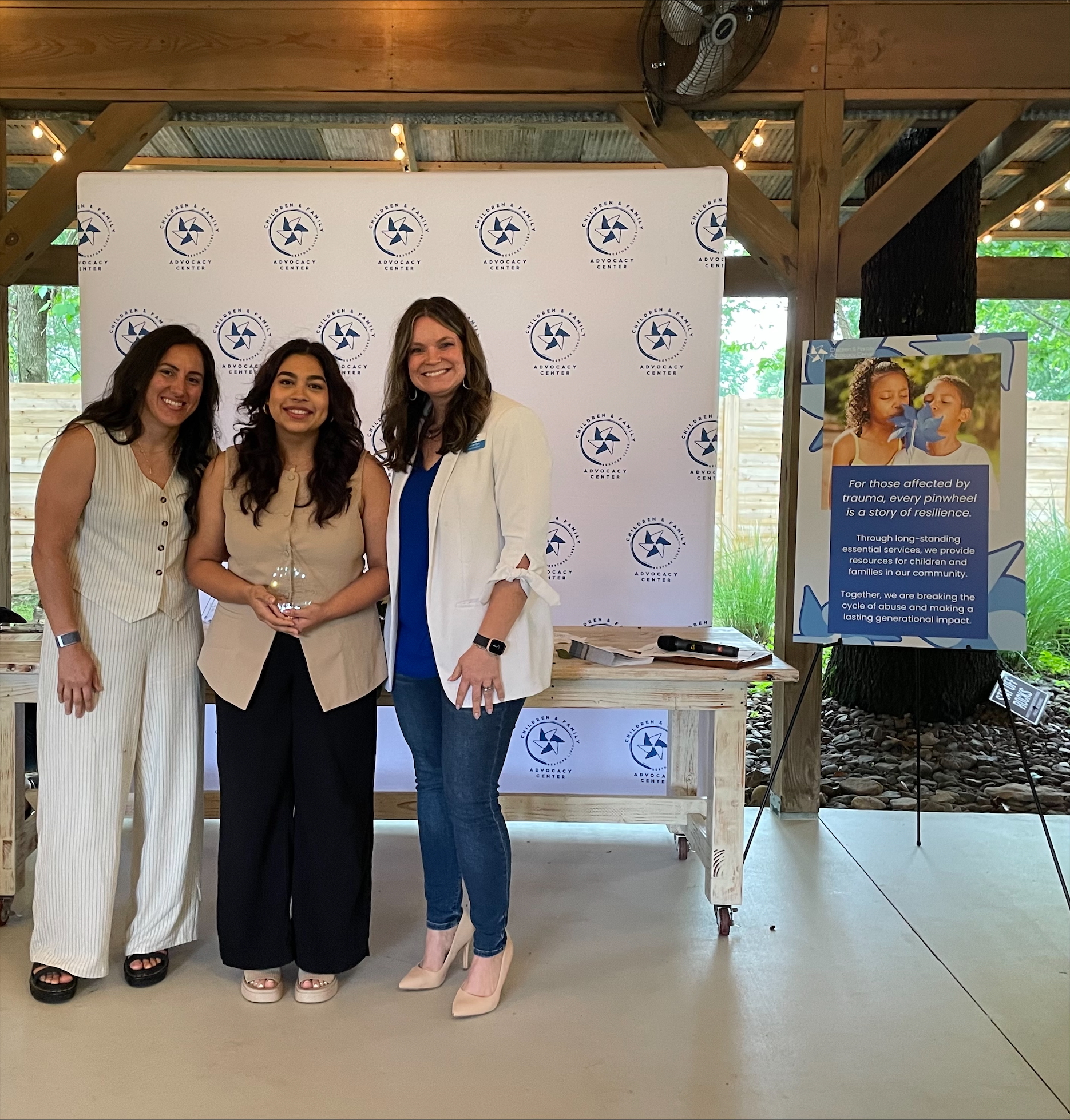 One of our advocates, Alejandra Torres, receiving an award from executive director, Natalie, Tibbs, and director of programs. Early Mallow for her contributions to those we serve.