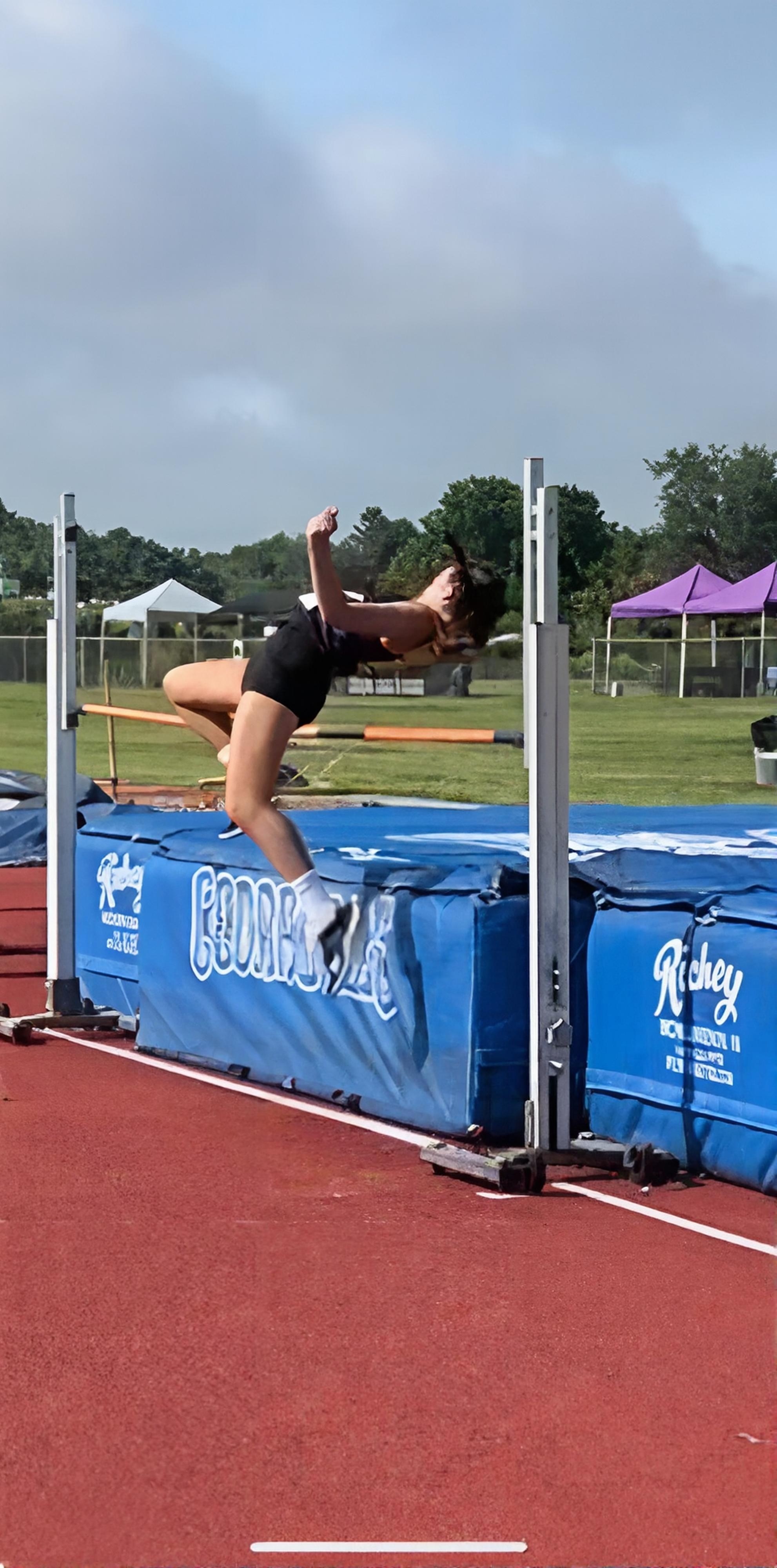 Alexa Weaver soars over the bar during a high-jump attempt, showcasing the talent she brings to the Liberty Warriors.