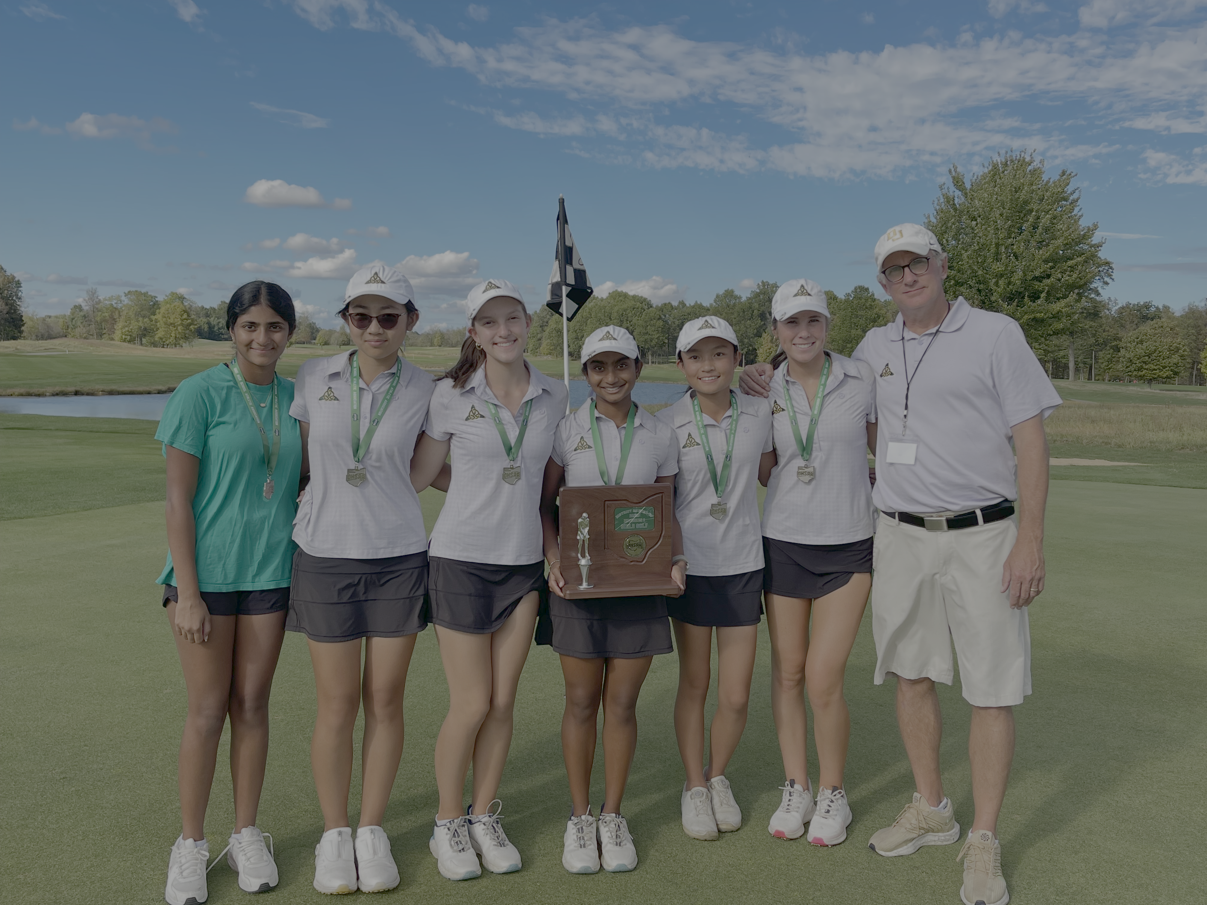 Proud smiles and well-deserved medals as the Celtics pose with their coach following a championship finish.
