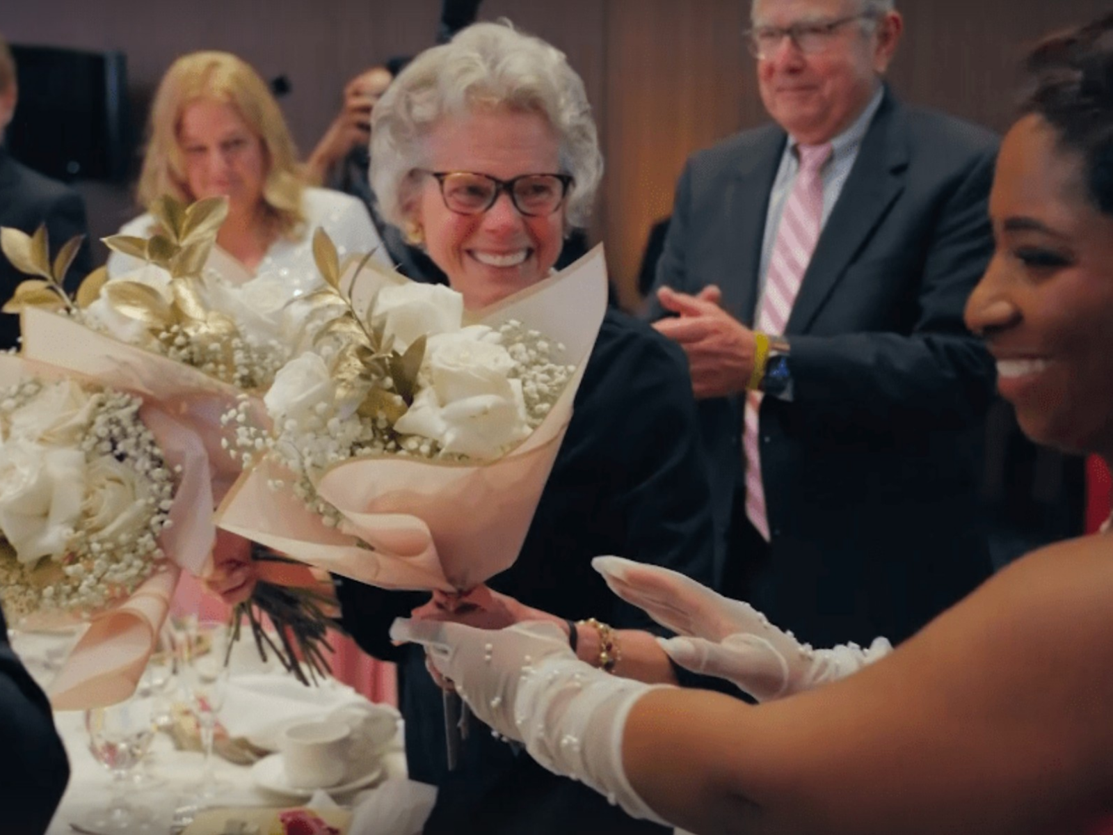 Chip receiving flowers from a past recipient of her flowers at the Ellie Fund gala; photo credit: CodedXStudios.