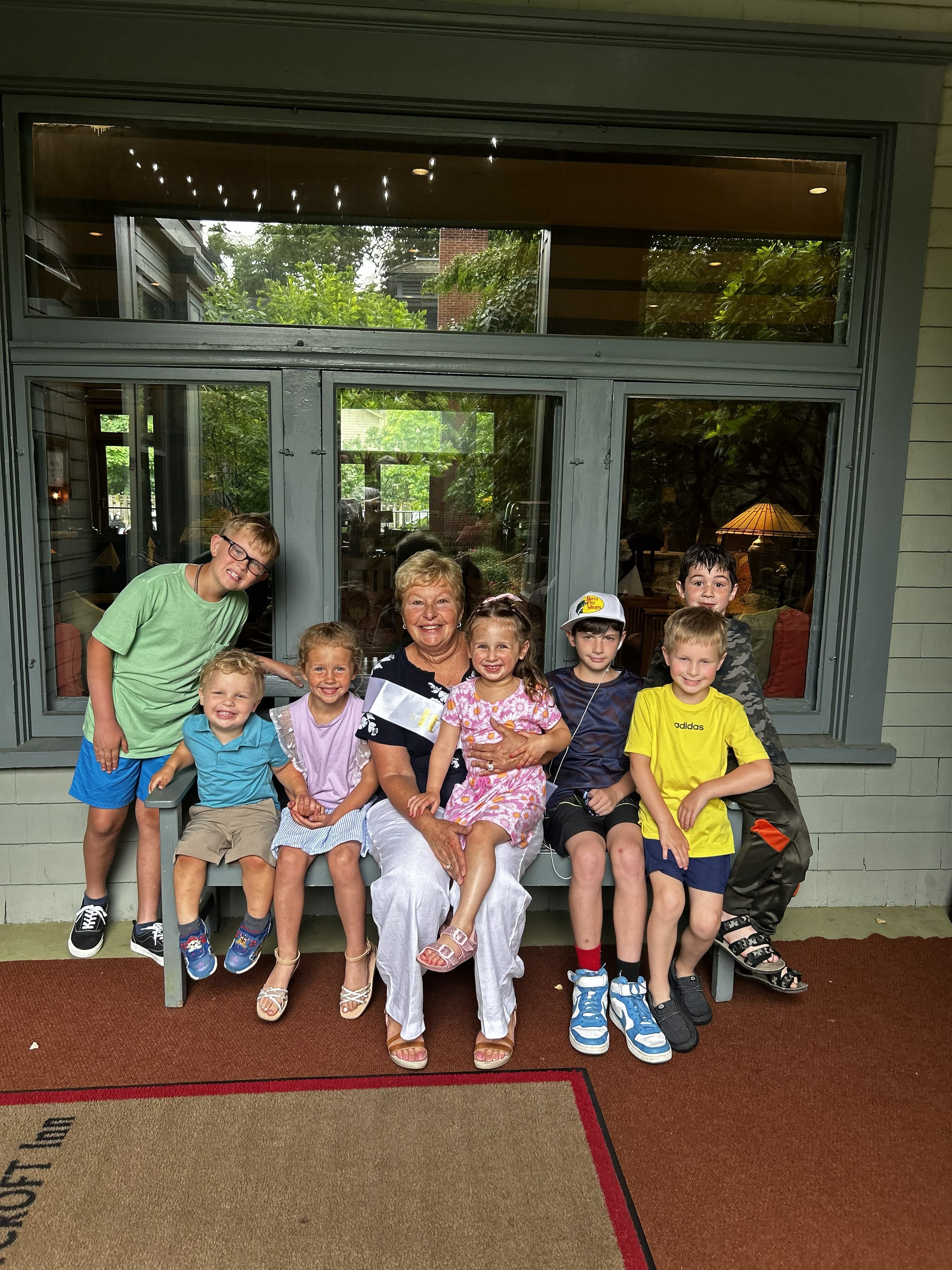 Bonnie with her seven grandchildren. Owen, who attends Mandala School, is pictured to her right in a Bass Pro cap.