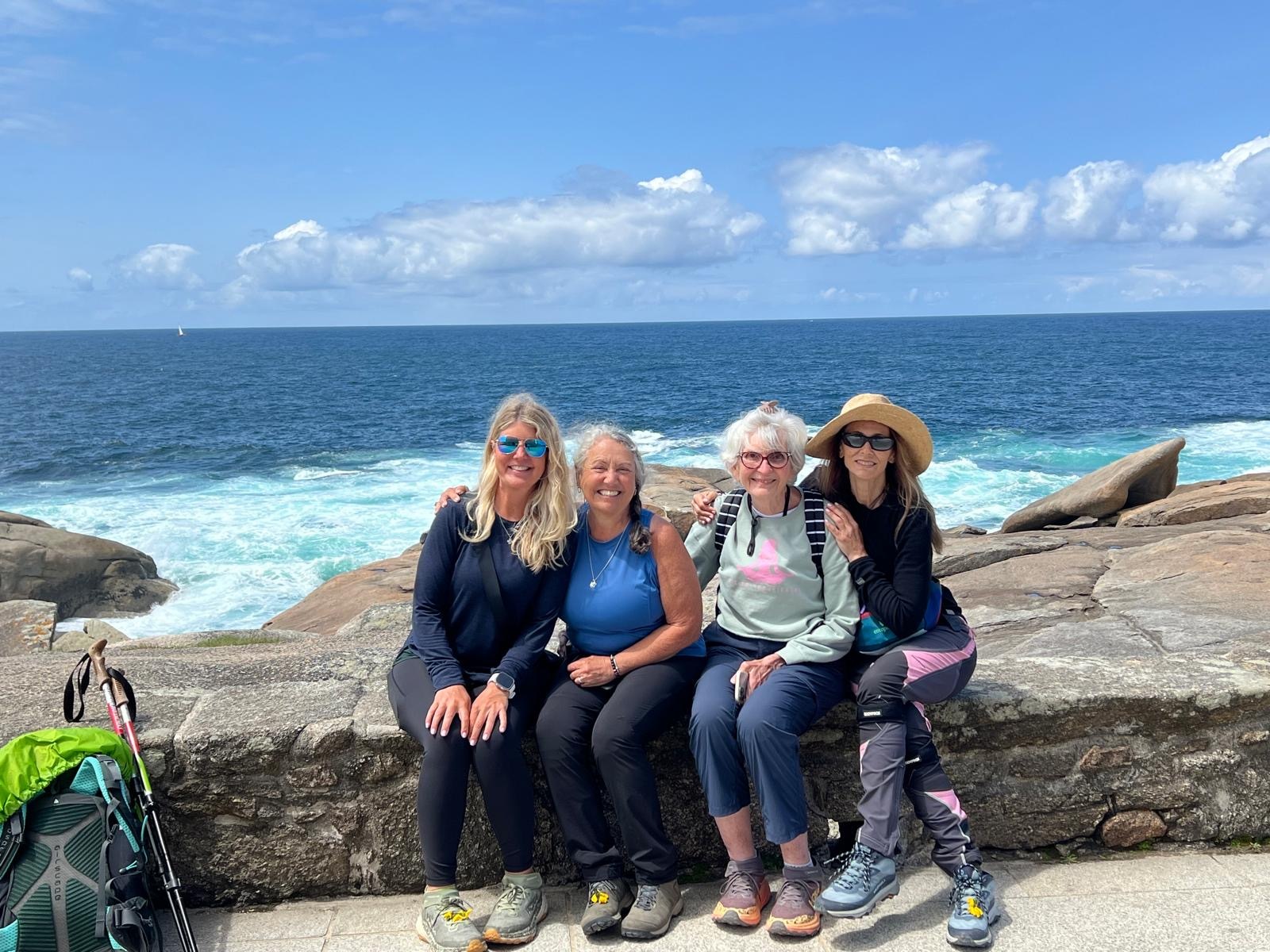 Nancy Penn, Laura’s neighbor in the Walking Stick neighborhood, pictured in minty green enjoying a moment with Camino Yoga Retreat friends in Muxia, Spain