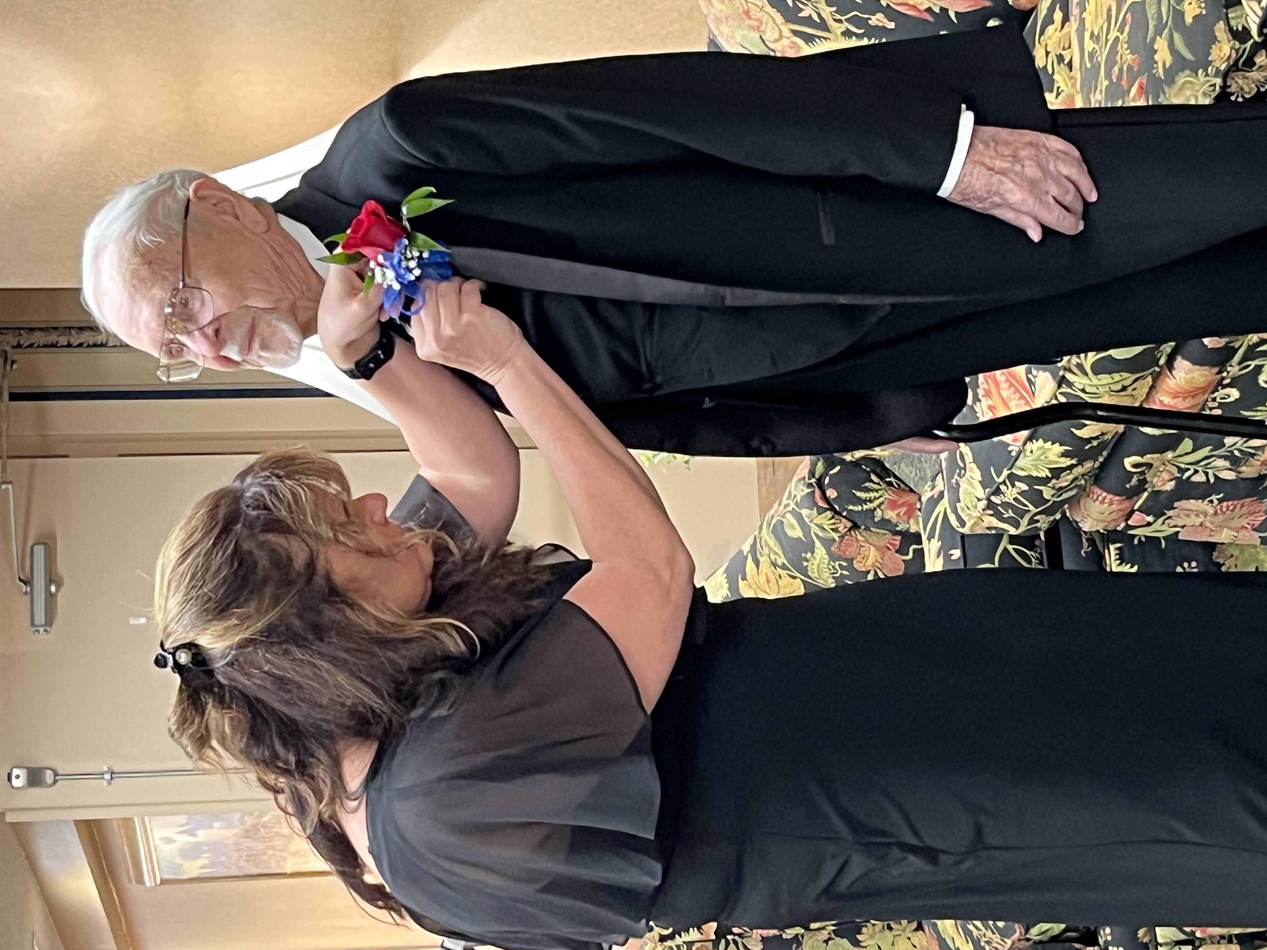 Metea Valley High School Tech Connect advisor Cary Peterson helps Ray with his boutonniere.