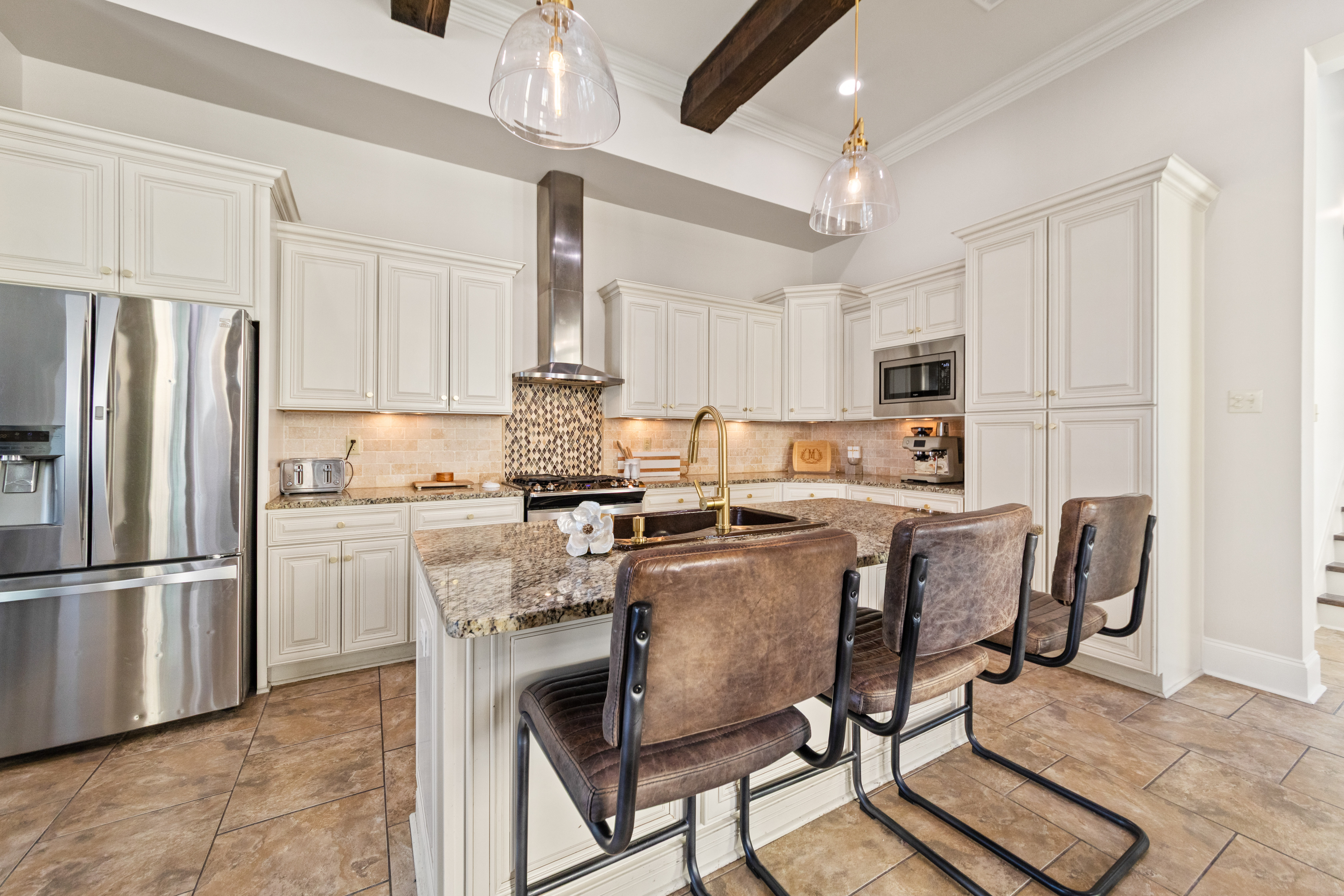 The spacious kitchen features an oversized island, abundant cabinetry, and an open layout designed for gathering with family and friends.