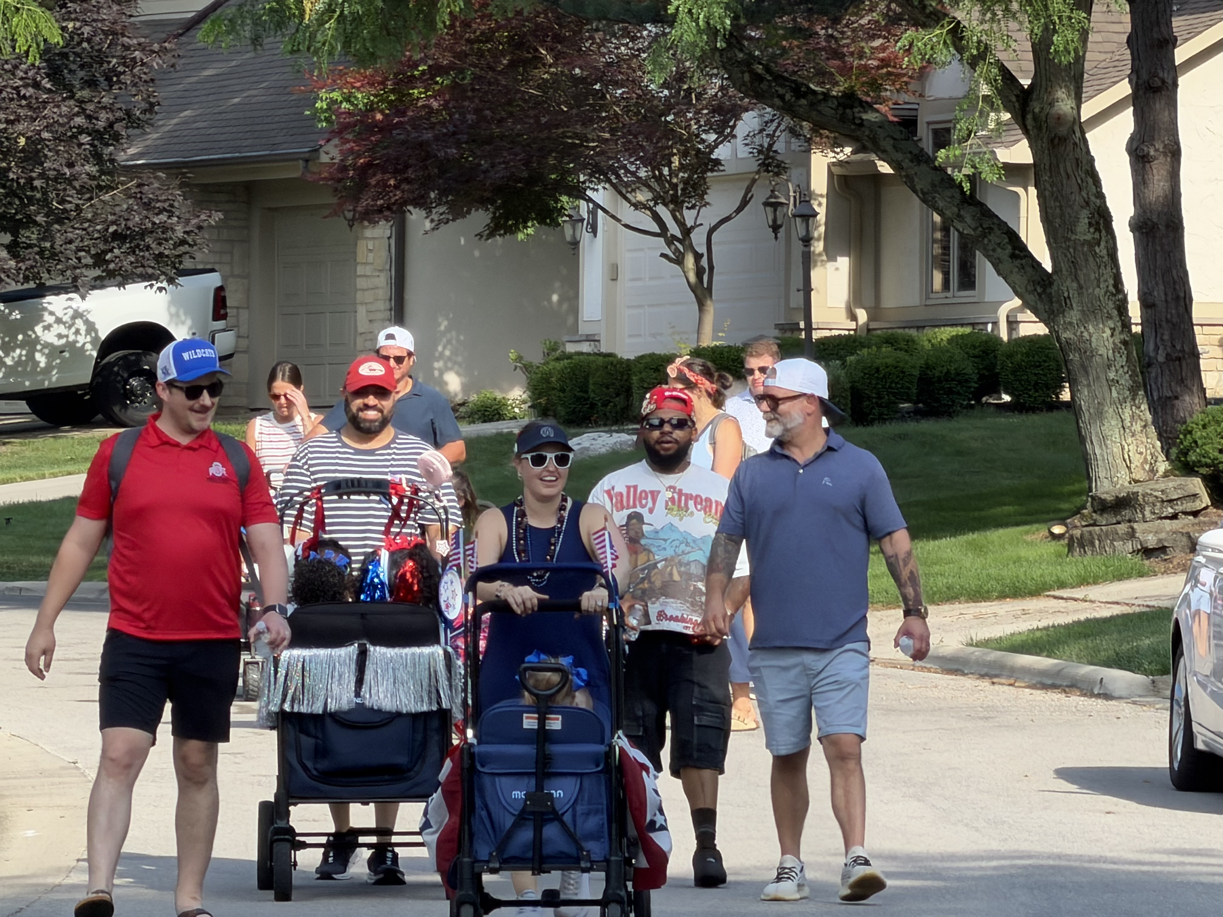 Shannon Richardson, Center, parades through her neighborhood with other neighbors to start a new tradition:  A 4th of July Parade.