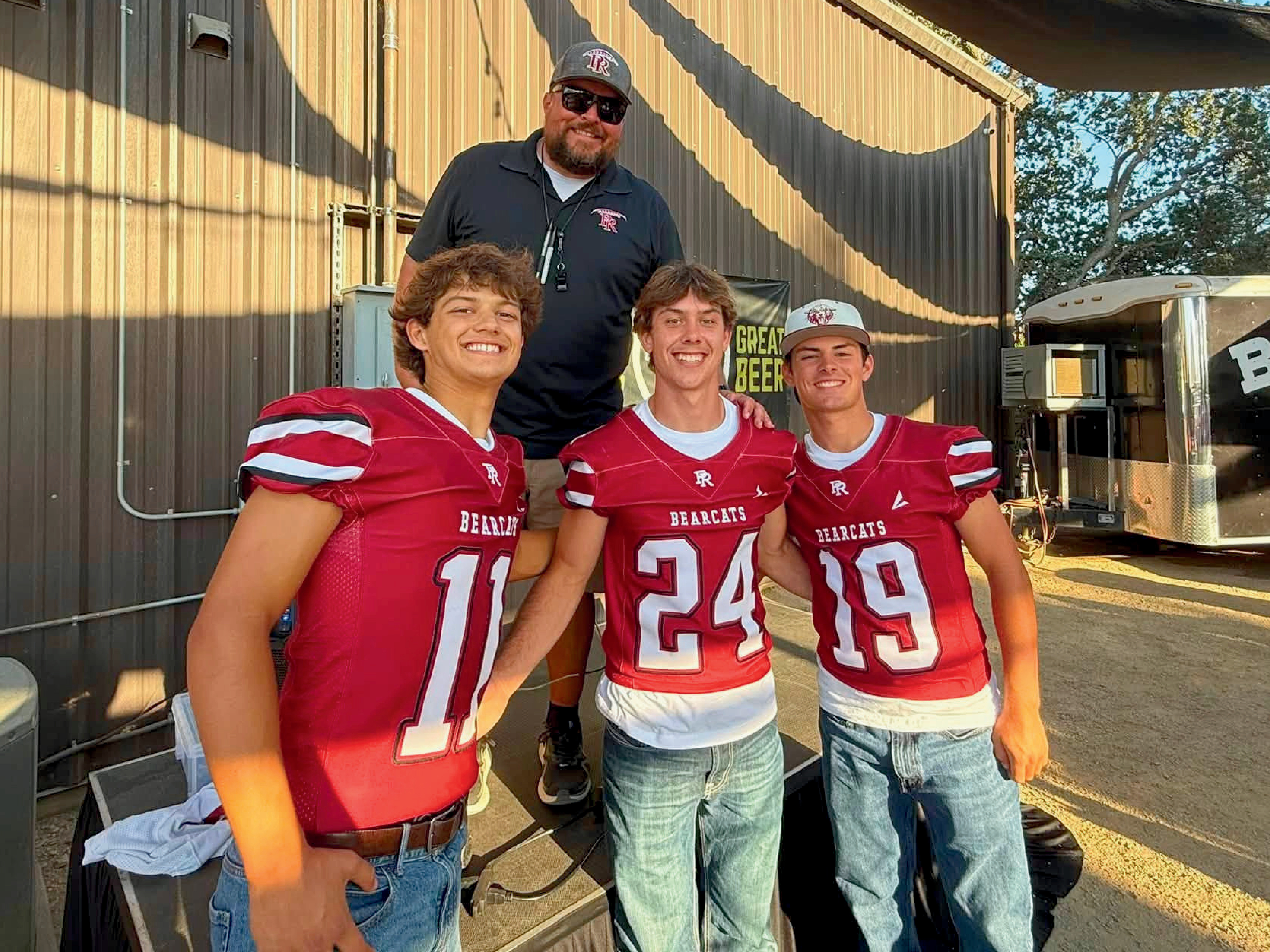 Emmett with his coach and teammates,  co-captain Matthew Amman and Xander Hermanson